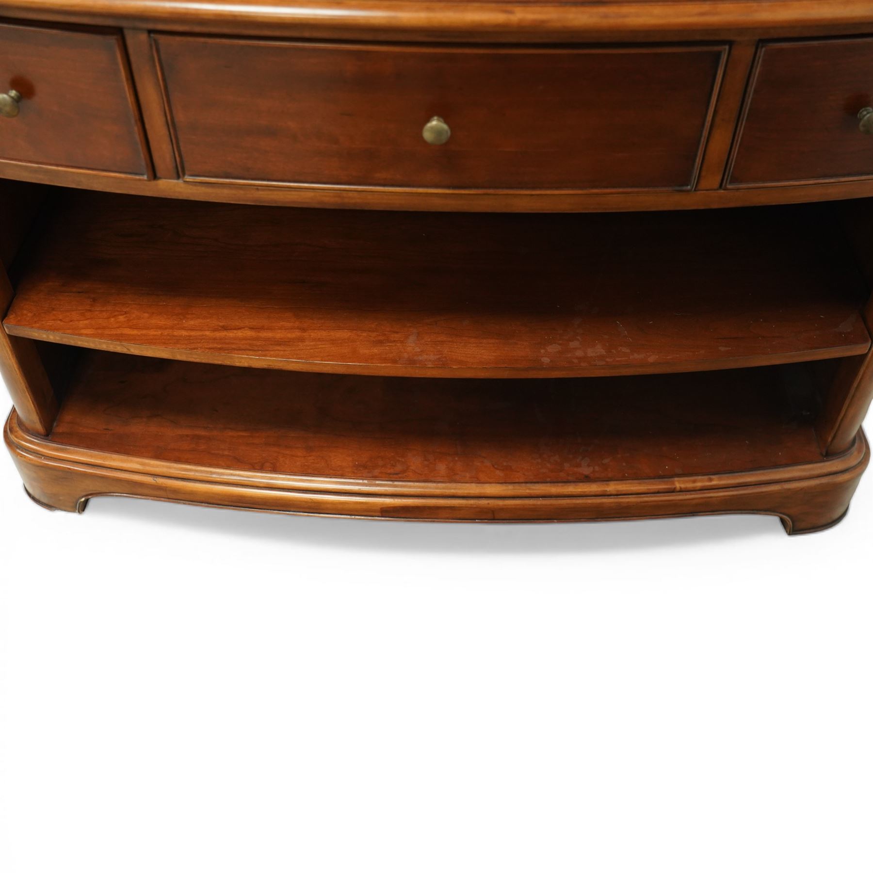 Willis & Gambier - curved sideboard, curved rectangular top, above three frieze drawers with brass pulls over two open recesses, on bracket feet 