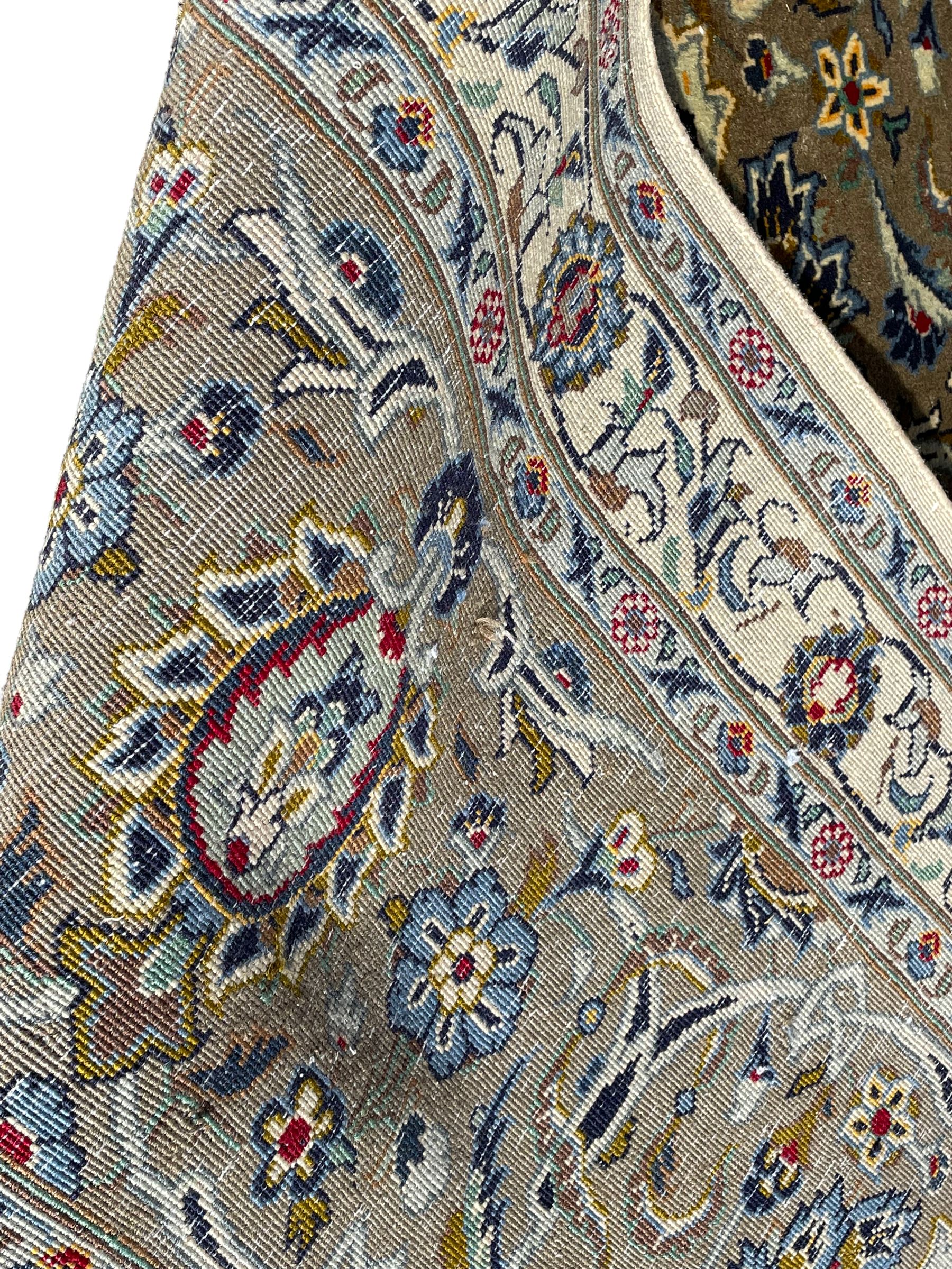 Persian Meshed carpet, ivory ground and decorated with intricate floral design with trailing scrolled branch, the central medallion decorated with stylised plant motifs, seven band border, the main band decorated with scrolls and flower head motifs