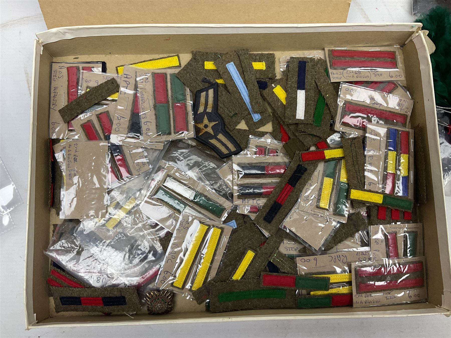 Quantity of military horse hair plumes and feather hackles, cloth stripes and regimental titles etc