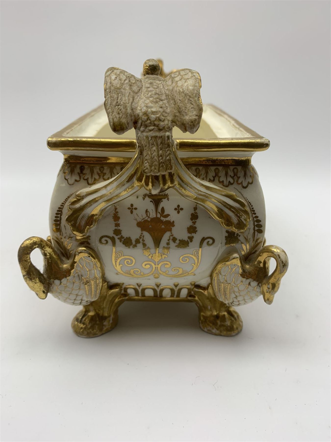 19th century Coalport bough pot, circa 1820, of bombe form, the body with twin handles surmounted by two birds and raised upon four feet modelled as swans, hand painted with two panels depicting an urn of flowers set against a mountainous landscape, the whole heightened in gilt throughout, H13cm L21cm