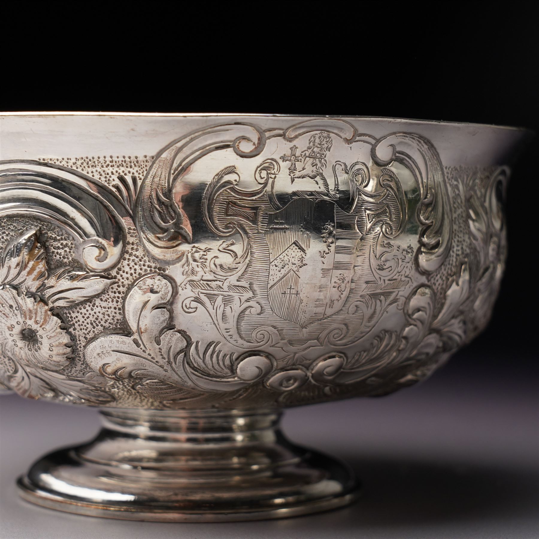 Matched three piece silver tea set comprising teapot of squat circular form London 1827,  milk jug of similar date and sugar bowl with Britannia standard marks, all with later embossed floral decoration and coat of arms, all marks rubbed