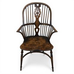 Late 19th century elm and beech high back Windsor armchair, the arched hoop back centred by a pierced wheel splat above a heart shaped lower piercing, with turned spindles and shaped arm rail, saddle seat, raised on turned legs united by a crinoline stretcher