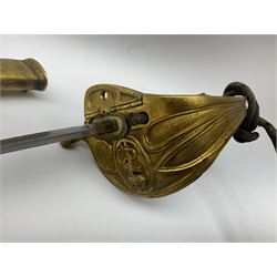 WW1 George V era 1827 Pattern Royal Naval Officer’s sword, the 80cm fullered steel blade decorated with crown, fouled anchor etc and marked Gieves Portsmouth London Edinburgh Devonport to the ricasso, gilded hilt with fouled anchor and crown, wire-bound ray skin grip, lion’s head pommel with mane backstrap, folding/locking langet and full bullion knot; in  leather scabbard having twin brass lockets with hand engraved panels and twin suspension rings L94cm overall. Provenance: By direct family descent from Brian Heathcote HMS Conqueror later Superintendant in the Liverpool Special Constabulary.