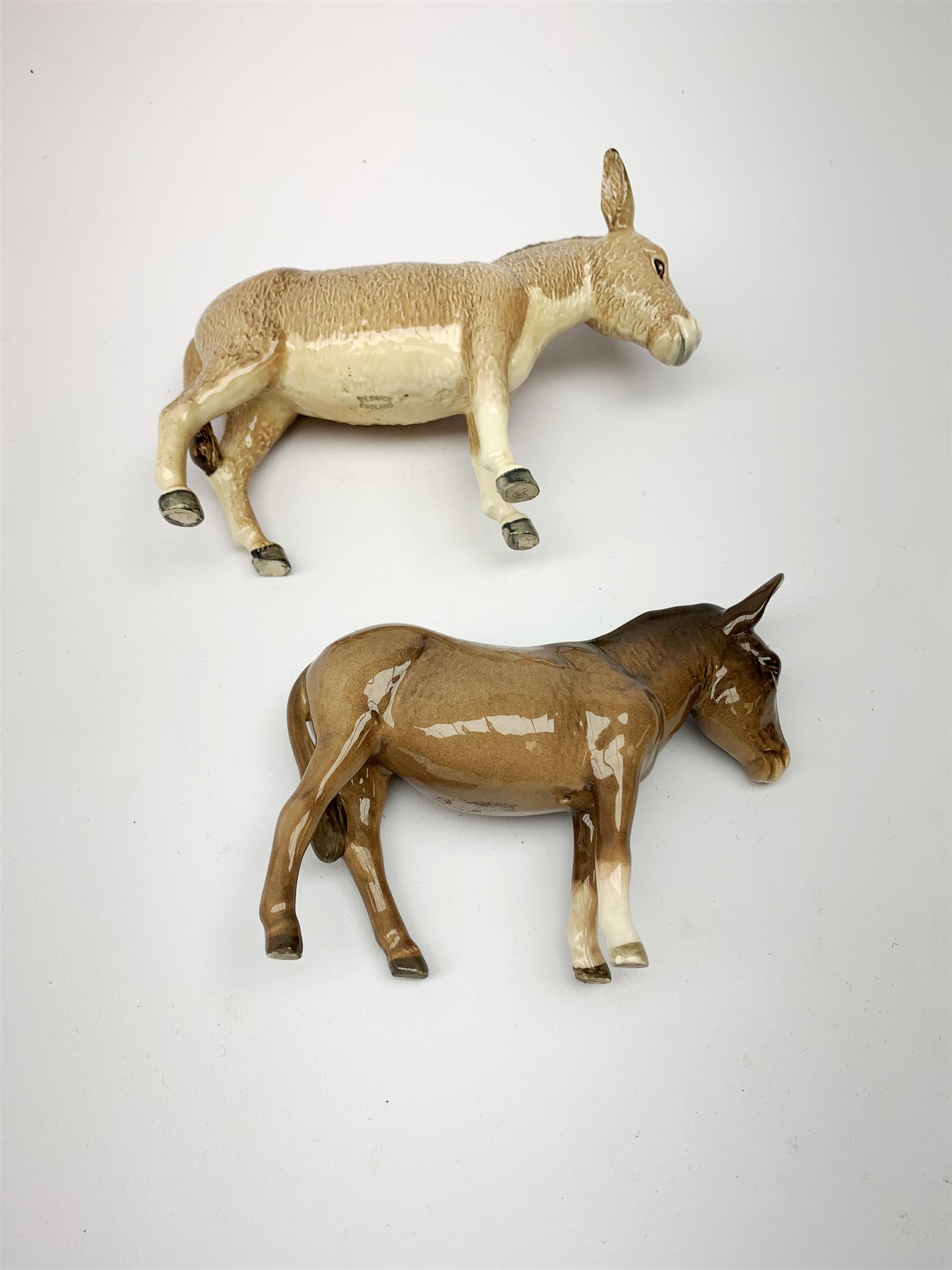 A group of Beswick figures, comprising two Charlie Wall Queen pigs, and a Charlie Wall Boy pig, two donkeys, sheep, and a lamb. 
