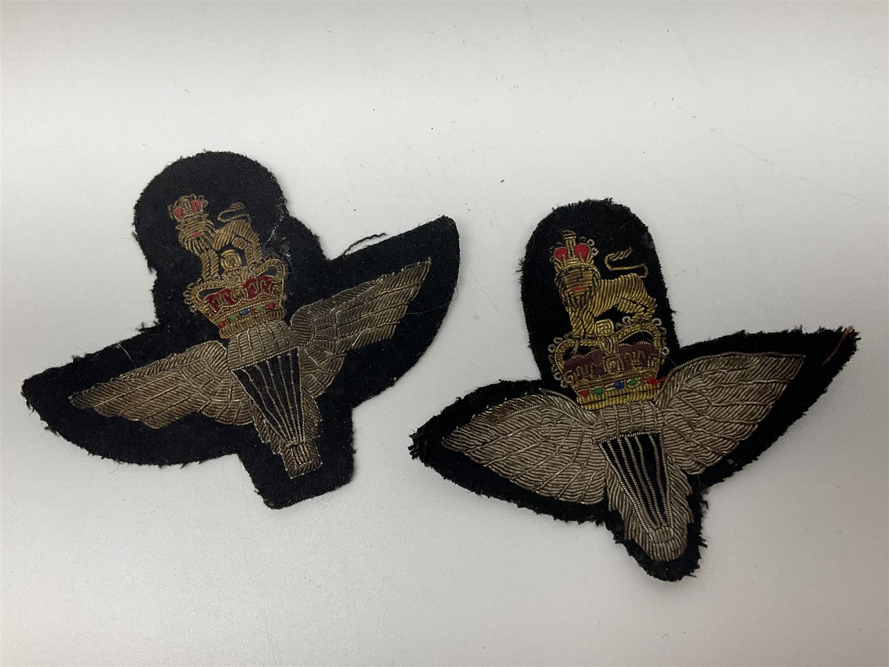 Parachute regiment - chrome crest on oak easel shield; three cloth badges; small silver plated figure; and pin badge; together with 10cm diameter cannon ball etc