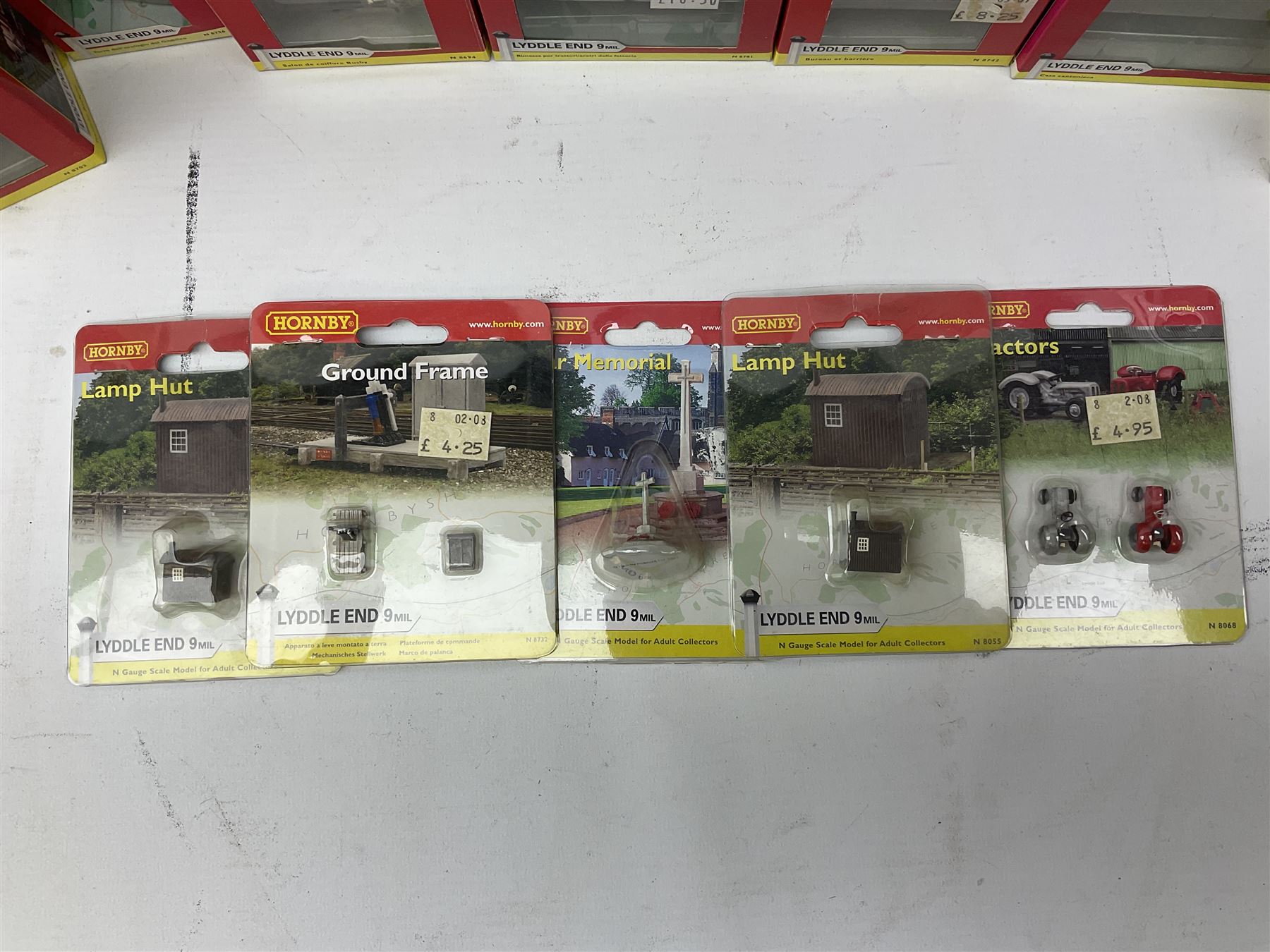 Hornby 'N' gauge - eighteen Lyddle End trackside buildings including The Old Toll House, Electricity Sub Station, Teesdale bakery, Mason's Arms Pub, various shops and hairdressers, farm buildings, Clock Tower etc; all boxed; and five Lyddle End blister pack cards of trackside accessories including Lamp Huts, Tractors, War memorial etc (23)