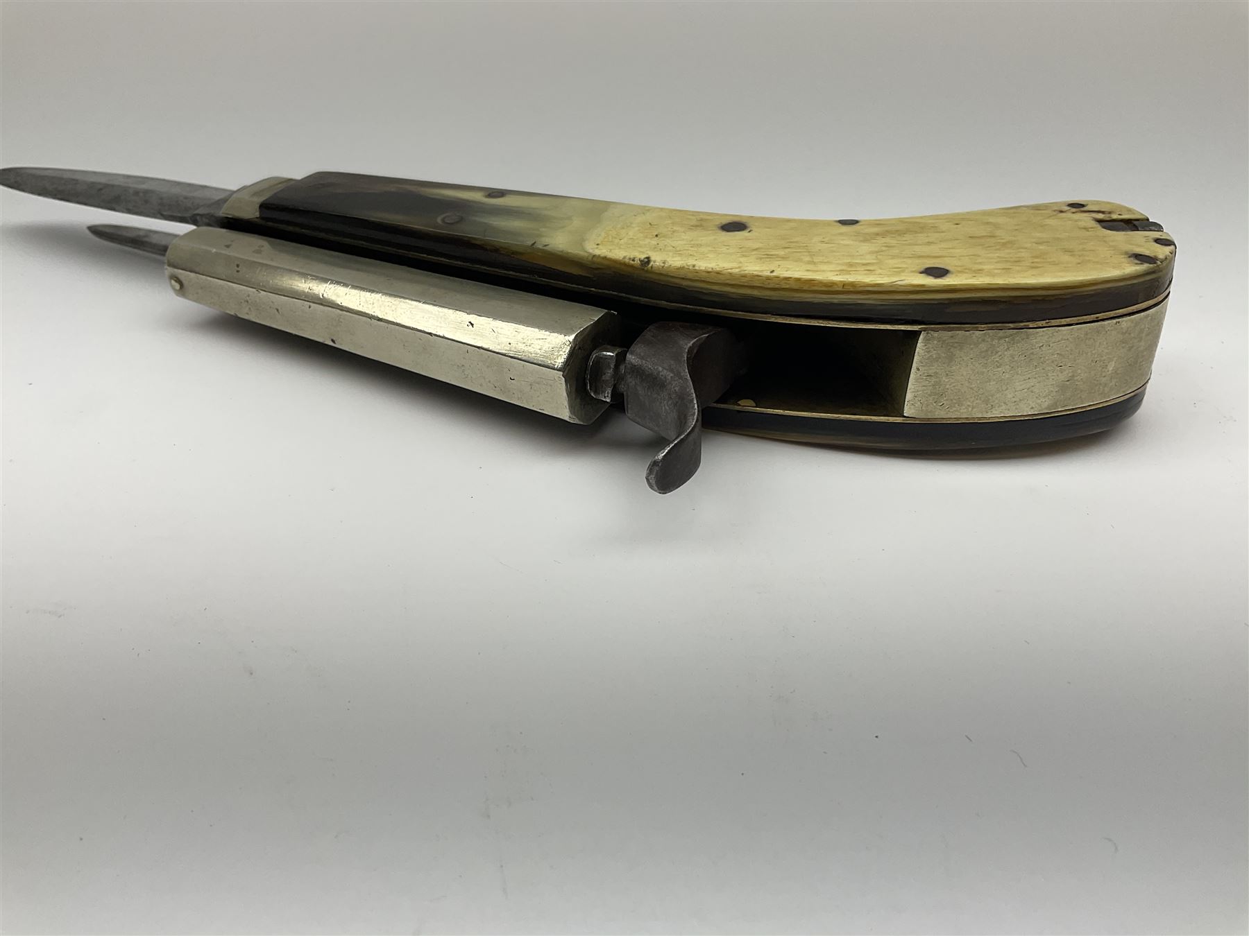 Mid-19th century James Rodgers Sheffield 160-bore (approx. 25cal.) percussion knife pistol with twin folding blades, known as 'Unwin & Rodgers Type', 9cm nickel tapering octagonal barrel with rear mounted nipple, boxlock central hammer action, smooth horn riveted side scales with nickel mounts housing nickel scissor action bullet mould, pair of tweezers and concealed butt compartment for ball/cap, folding trigger and two blades, one 8cm dagger style and one 5.5cm single edged utility blade L17.5cm overall closed