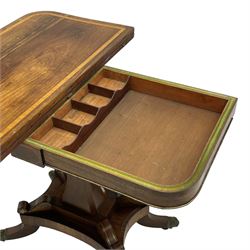 Regency rosewood and brass inlaid card table, the rectangular fold-over and swivelling top with rounded corners with a satinwood band, opening to reveal a blue baize lined interior playing surface, the frieze with a raised panel with satinwood stringing and a lower beaded brass edge, the concave and canted column with a shaped platform base applied with scrolls with brass star inlays and stringing, quadruple splayed supports terminating in foliate cast cups and castors