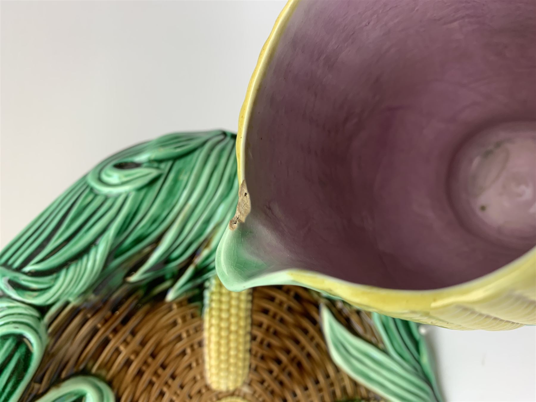 A Victorian majolica bread plate depicting corn within a woven basket, L33cm, together with a Victorian majolica jug modelled in the form of a corn cob, with registration mark beneath, H22cm. 