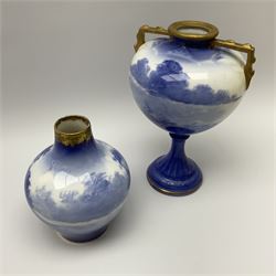 Two Royal Doulton blue and white vases, comprising an example of bulbus form decorated with children, no 636, H14.5cm, and an example of amphora form decorated with woman in countryside setting, no 938, H21cm, each with printed marks beneath. 