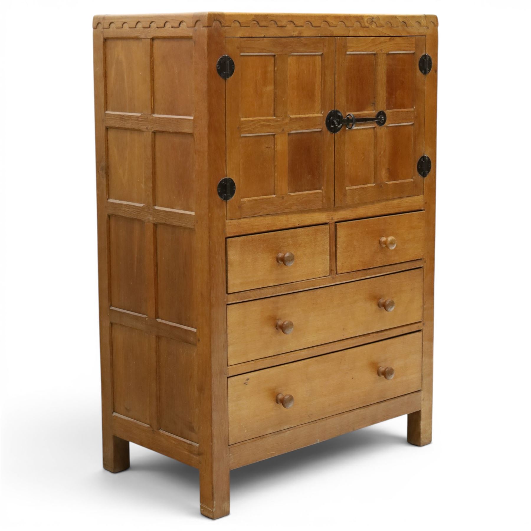Mouseman - mid-20th century adzed and panelled oak tallboy chest, arcade carved cresting rail over two panelled cupboard doors with wrought iron fittings and latch, enclosing single shelf, over two short and two long drawers with lightly adzed facias and turned knob handles, raised on square supports, relief carved mouse signature, by the workshop of Robert Thompson of Kilburn