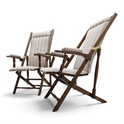 Pair of early 20th century oak framed garden reclining and folding deckchairs, high back and seat upholstered in striped fabric with padded armrests