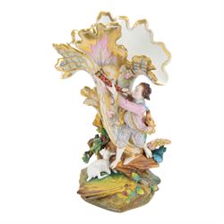 Pair of late 19th century French Letu & Mauger bisque figures, modelled as a gallant and his companion, with impressed marks beneath, H35.5cm, together with a 19th century French mantle vase, in the manner of Jacob Petit, the vase of cornucopia form painted with rose sprays and heightened with gilt, mounted with the figure of a trumpet player, upon a naturalistically modelled base mounted with a recumbent goat, H35cm