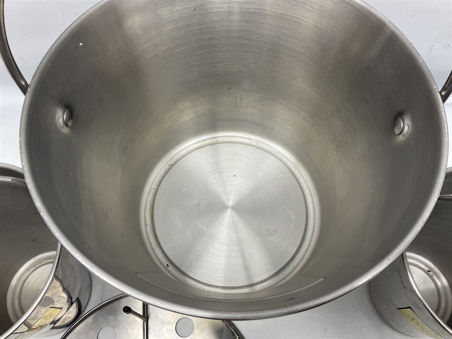 Stainless steel Laurent-Perrier champagne bucket, with engraved brass plaque and grip to swing handle, together with two matching smaller, largest D38cm (3)