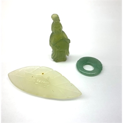 A small carved jade leaf detailed with a fish, L7.5cm, together with a carved jade pendant detailed with a fish, D3cm, and a small carved pendant modelled as a female figure, H5.5cm. (3). 