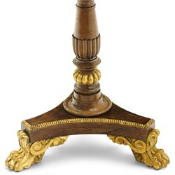 French Empire design rosewood and parcel-gilt occasional table, the circular top with sunburst veneer and giltwood gadrooned edge, raised on a turned and lobed pedestal terminating to a triform platform base with gilt beading, raised on three large paw feet with scrolling foliate brackets