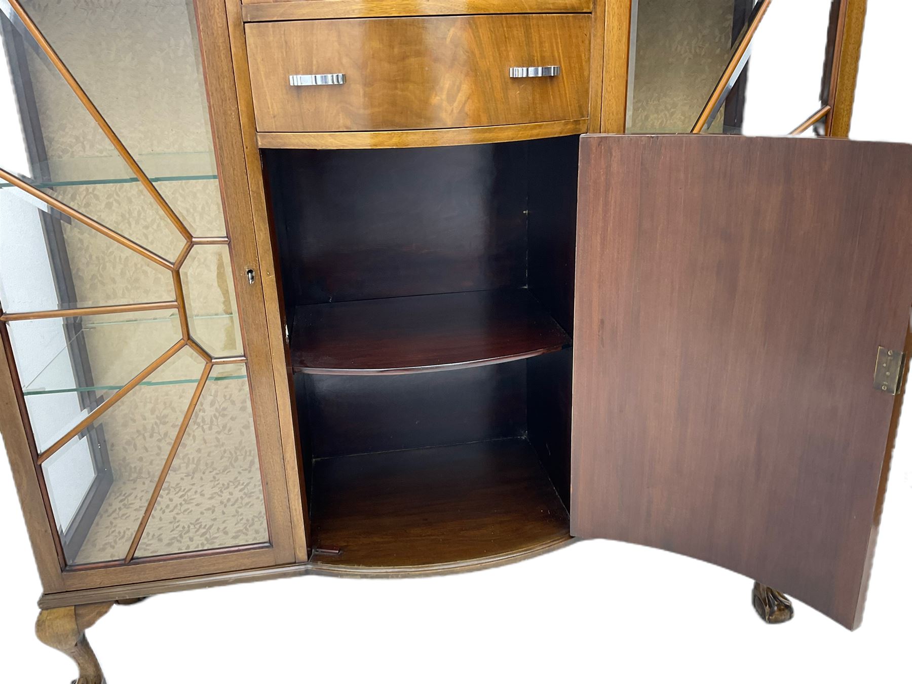 Mid-20th century Art Deco style walnut display cabinet, two central drawers over cupboard flanked by two bevel glazed display cabinets with sunburst astragal glazing, on ball and claw cabriole feet