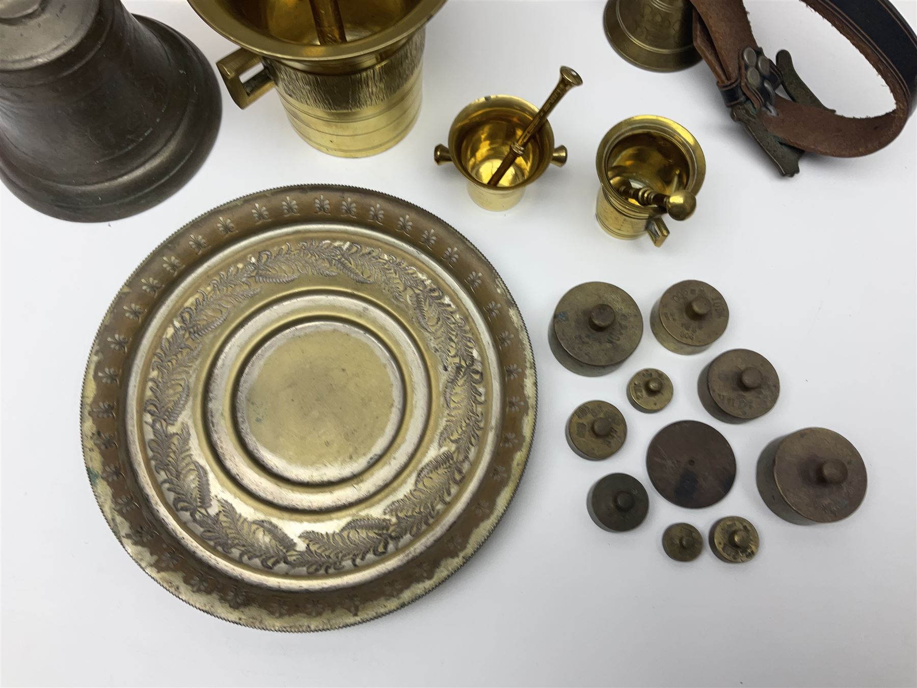Four brass pestle and mortars, to include two miniature examples, together with other brassware including four branch candleabra, bells etc
