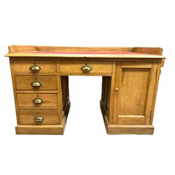 Early 20th century oak ‘Headmasters’ twin pedestal desk, three-quarter raised gallery back and inset leather writing surface, fitted with central drawer flanked by four graduating drawers and single cupboard