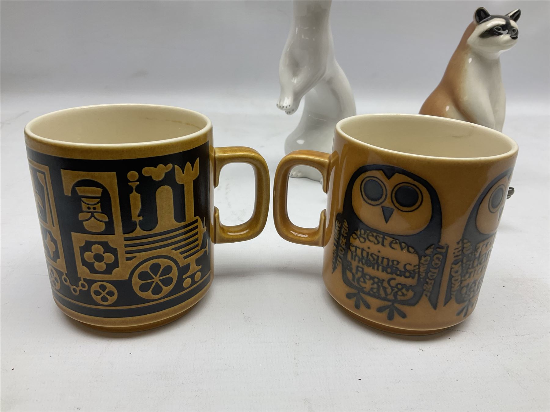 1970's Hornsea mugs, comprising Train Robber pattern designed by John Clappison and Owl from the ‘Newsprint’ Zoo range designed by Jack Dadd, and three USSR figures of animals comprising raccoon, ferret and badger