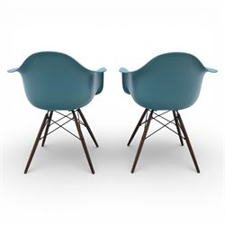 Vitra - Pair of Eames DAW armchairs, moulded plastic seats in teal with integrated armrests, blue upholstered seat cushions, supported on stained wooden dowel legs with black wire cross bracing