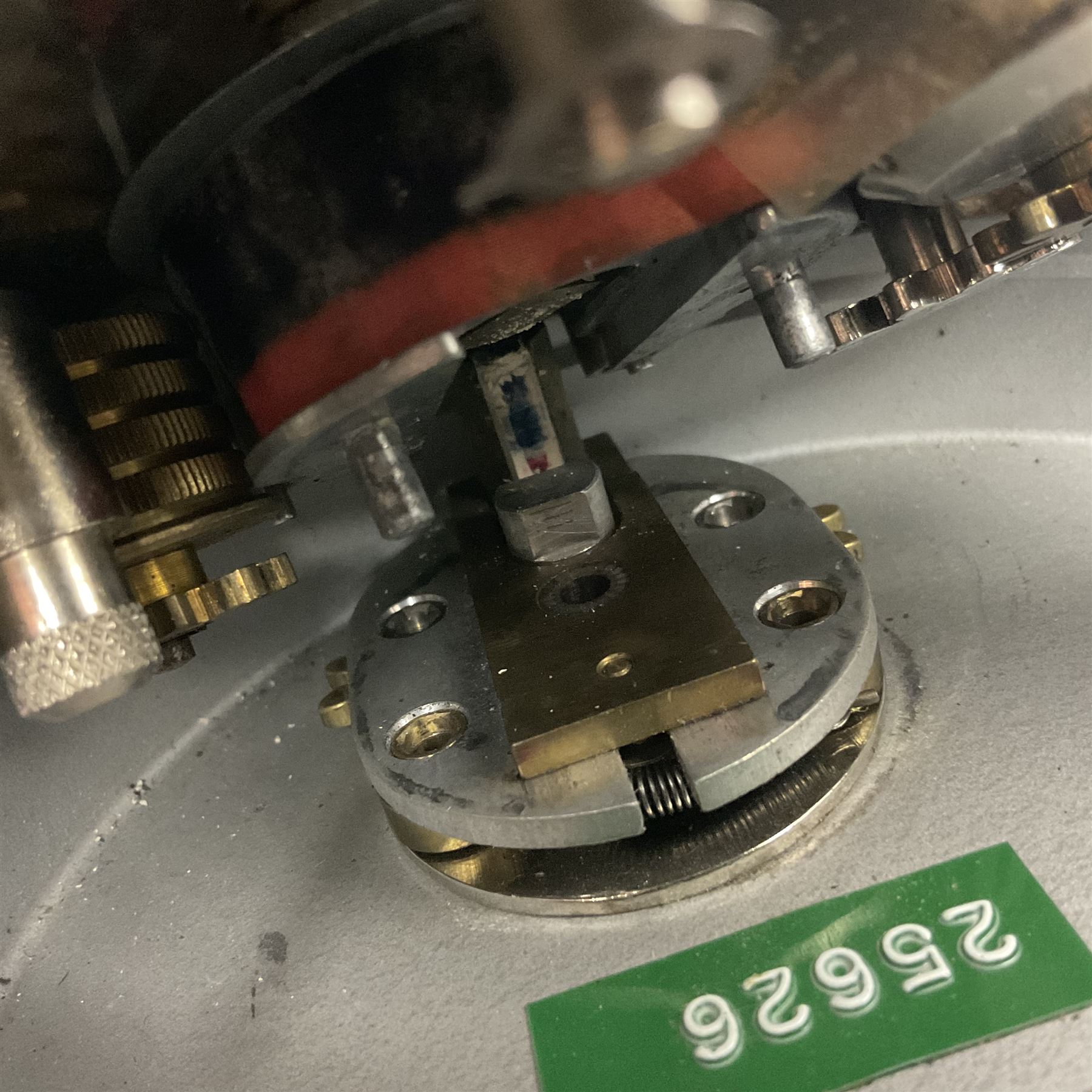 Metal cased drum shaped travelling clock with grey hammered finish, French clockwork movement and stitched leather outer case with shoulder strap; bears manuscript label 'Royal Armament Research and Development Establishment - serial no.09433' D13cm overall