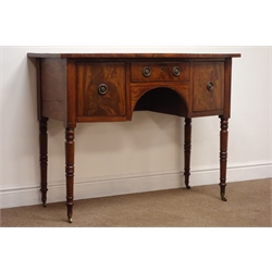  William lV mahogany bow front kneehole sideboard, two deep and one shallow drawer outlined with satin wood and ebonised stringing, brass ring handles on ring turned tapering legs with brass sockets and castors, W108cm, D52cm, H83cm  
