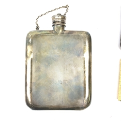 An Asprey silver plated hip flask, of rounded rectangular form with engine turned panel decoration to the front and back, the front panel with vacant rectangular cartouche to the upper left corner, H14.5cm, together with a gold plated Dunhill cigarette lighter with bark textured effect body, H6.5cm. 
