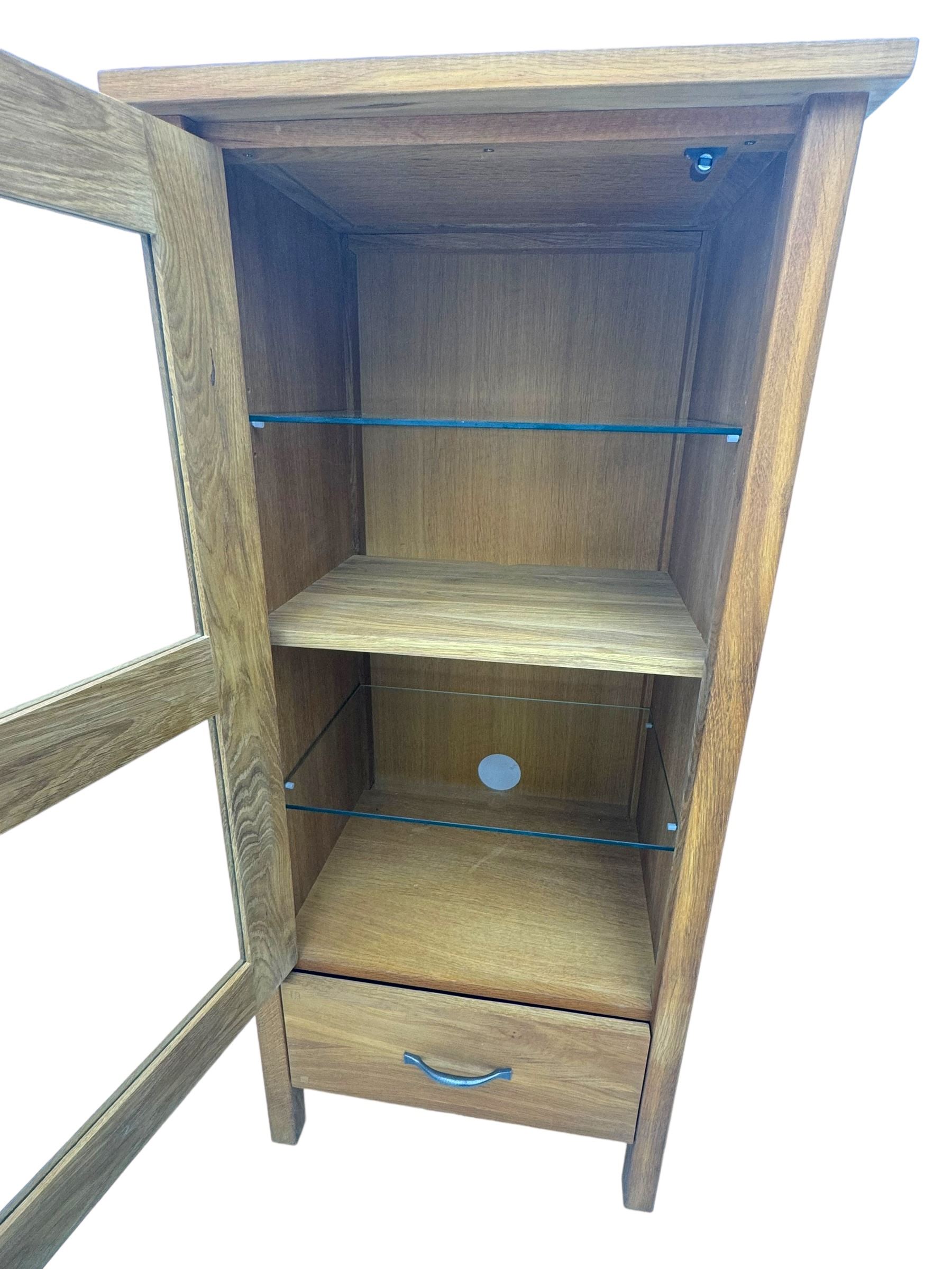 Laura Ashley - contemporary Milton oak display cabinet, featuring single door with two glass panels and pewter effect handle, enclosing one fixed oak shelf and two adjustable glass shelves, access hole at the bottom shelf, over single drawer with matching handle, on square legs