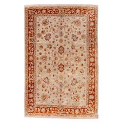 Indian Agra hand knotted rug, the pale beige field decorated with scattered floral sprays ...
