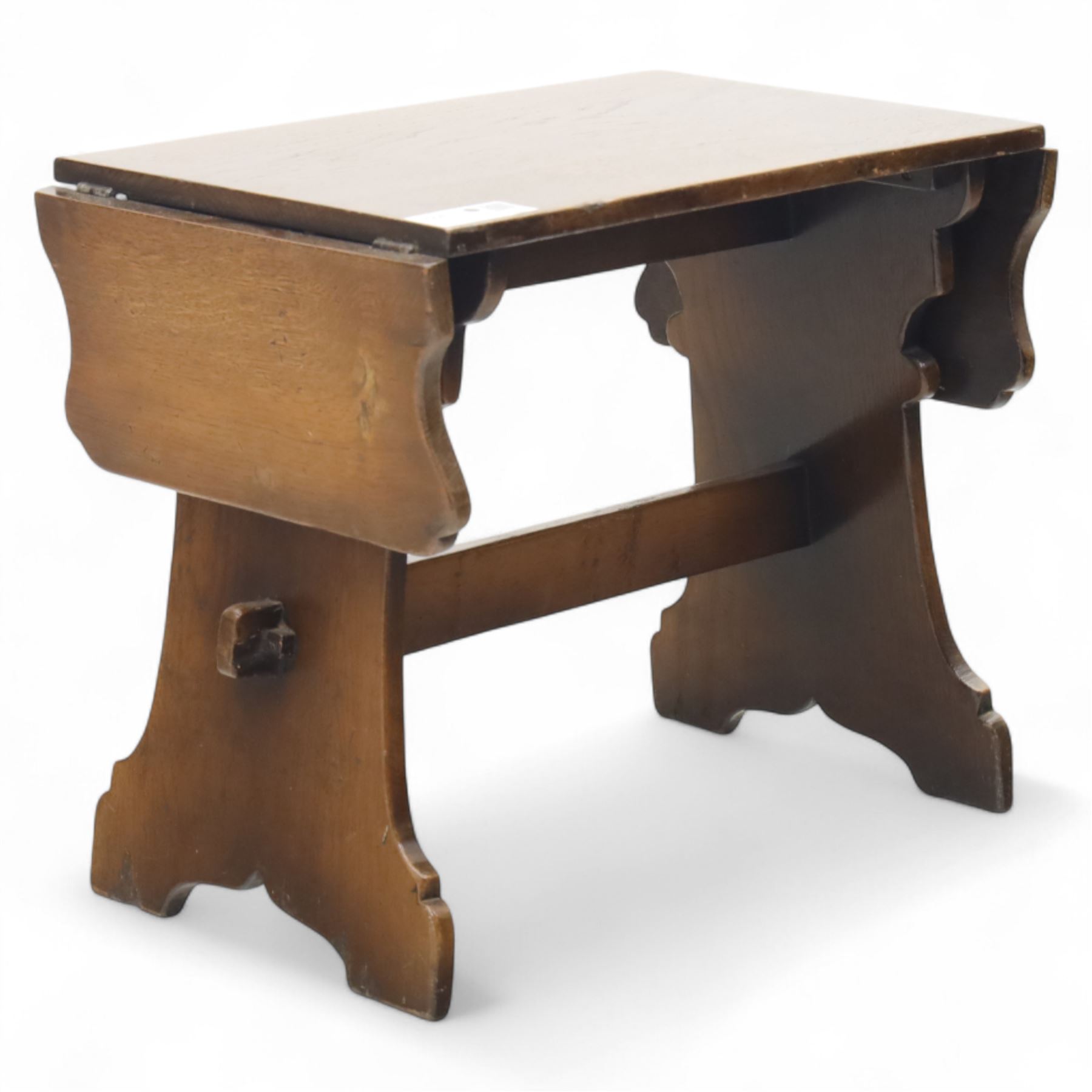 Early 20th century oak drop leaf cottage table, rectangular top with twin hinged leaves, on shaped trestle end supports united by central stretcher