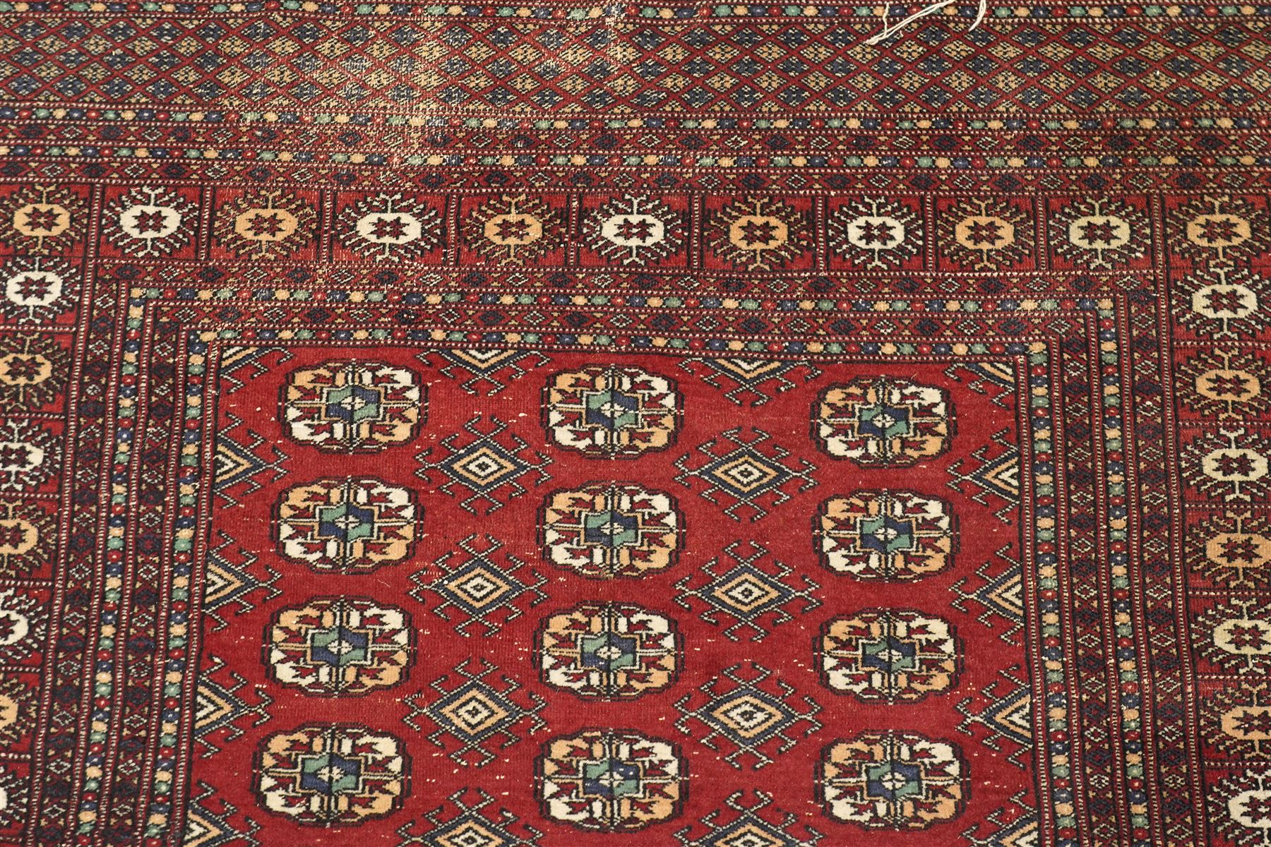Two hand-knotted rugs, comprising Turkoman Ersari rug and Bokhara rug, Turkoman Ersari hand-knotted rug, terracotta ground with two rows of repeating octagonal guls interspersed with geometric motifs, enclosed by multiple geometric borders, fringed ends, H125cm, W93cm; Bokhara hand-knotted rug, madder red ground with three rows of repeating Tekke guls interspersed with geometric motifs, enclosed by multiple stylised floral and geometric borders, fringed ends, H188cm, W126cm