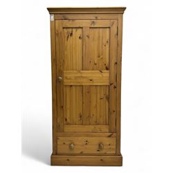 Pine single wardrobe, enclosed by single panelled door, fitted with single drawer, on plinth base 