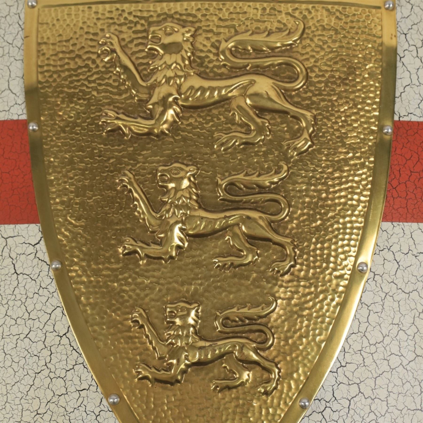 Five wall hangings, modelled as shields, decorated to the centre in relief with three lions 