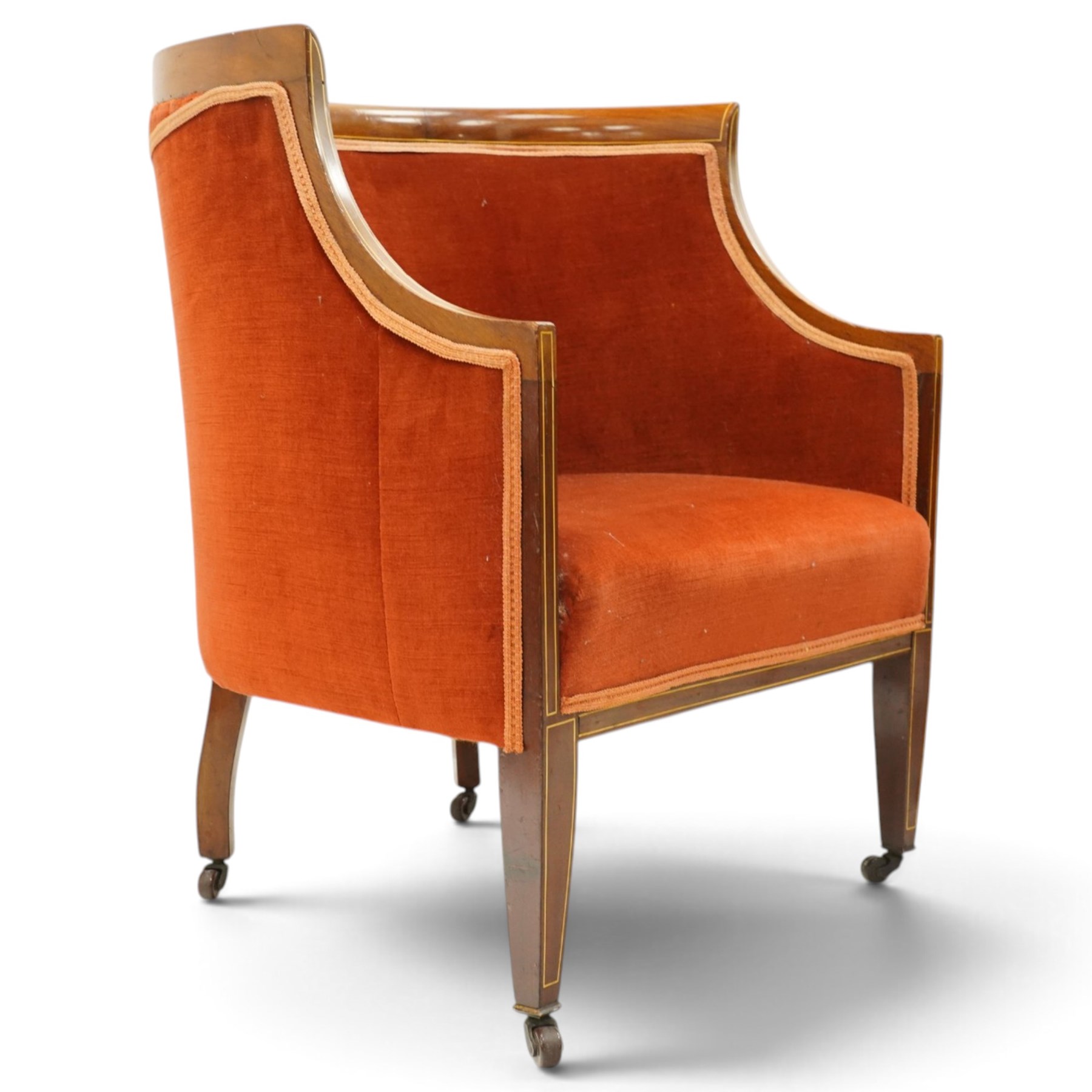 Pair of Edwardian inlaid mahogany tub armchairs, traditional shape with satinwood stringing, upholstered in crimson fabric with sprung seat, on square tapering supports with castors