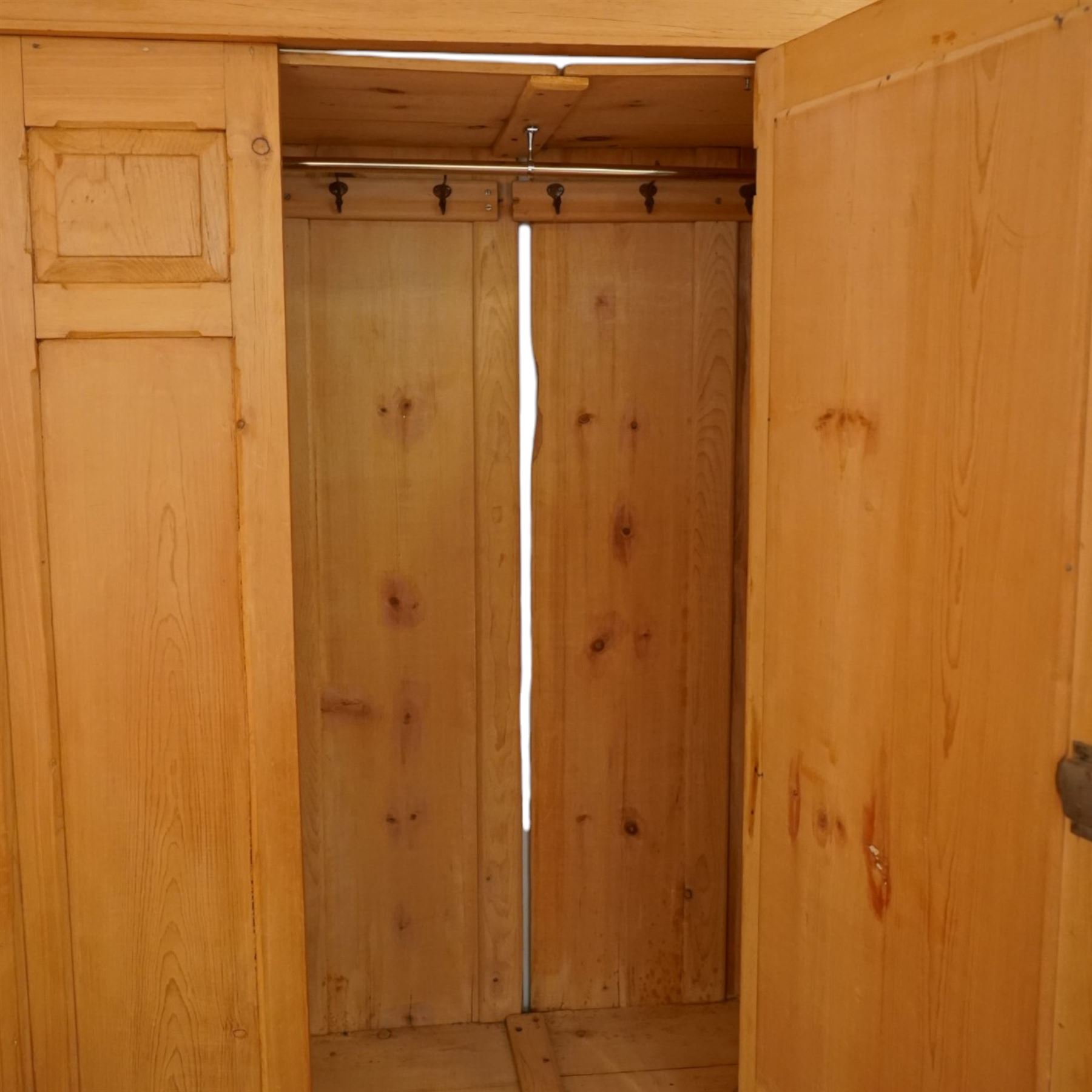 Victorian waxed pine wardrobe, carved projecting cornice with mirrored door, enclosing clothes hooks and rail, above a single drawer with glass knobs
