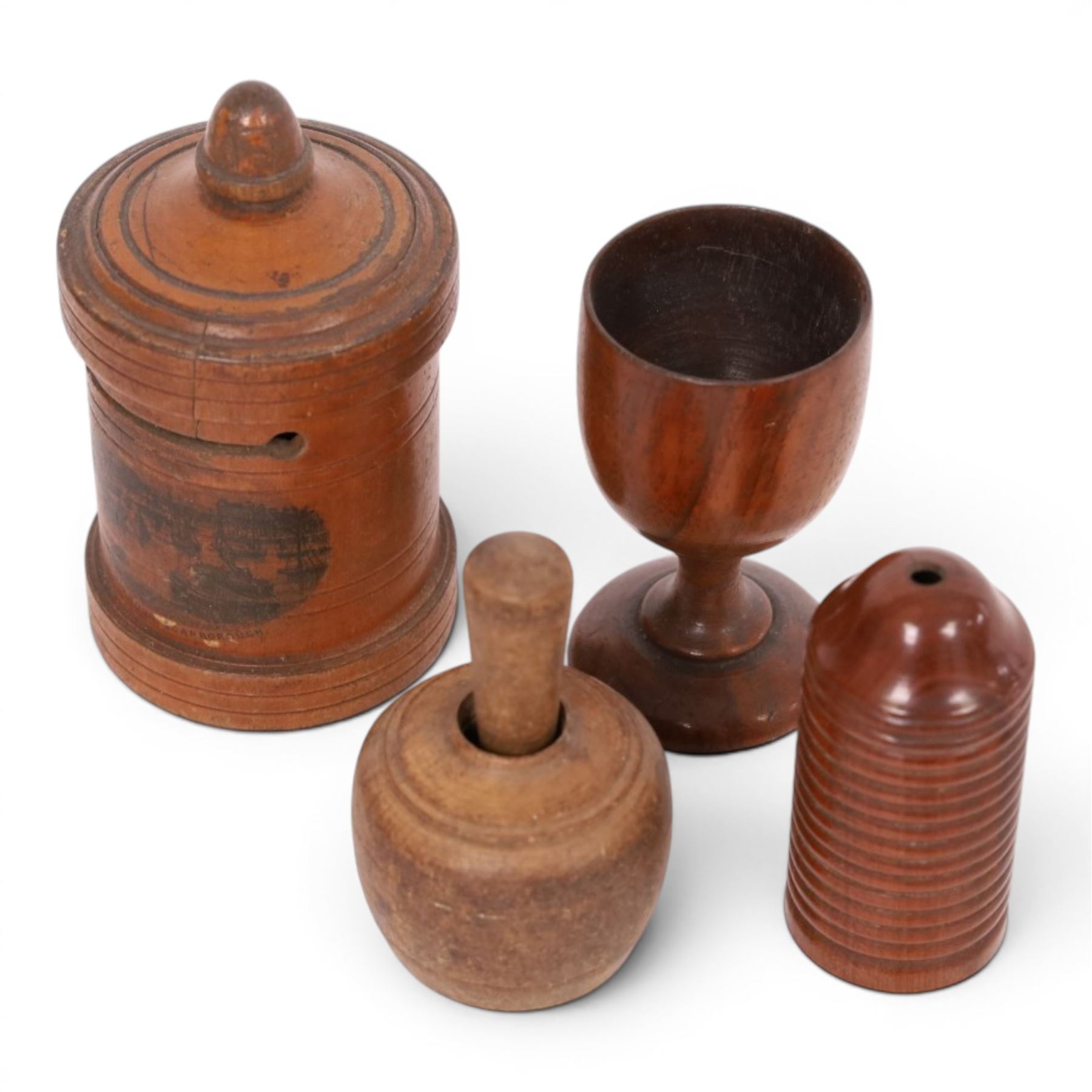 Group of treen, comprising, Mauchline ware coin box, box modelled as pear, egg cup, butter stamp, bell push, sewing implement, weaving tool, and box modelled as book