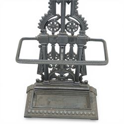 Late 19th century cast iron hall stand in the style of Christopher Dresser, cross shaped upper section with radiating wheel motif and applied hooks, architectural upright with pierced Gothic and geometric detail, fitted with rectangular drip tray and pierced surround, raised on stepped plinth base with bead decoration