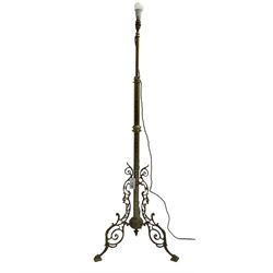 Victorian brass floor standing oil lamp, column decorated with ivy and acanthus leaves, the tripod base pierced with scrolled foliate decoration, with ivory and gilt shade, later converted to electricity