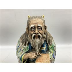 Late 20th century Japanese figure of a sage, partially glazed, modelled sitting cross-legged pointing to a tablet laid in his palm, his head with long hair and horns and his blue robe with leaves in greens, blues and grey, with pierced circular display stand, together with pair of Japanese satsuma vases, tallest H16cm