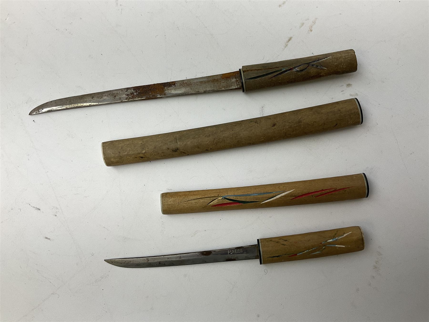 Malayan Kris dagger, the 31.5cm double edged straight heavy damascus blade with copper ferrule; carved hardwood grip; in large wooden throated scabbard with floral decorated white metal covering L47.5cm overall; a kris blade with adapted antler grip; and five various small daggers/letter openers (7)