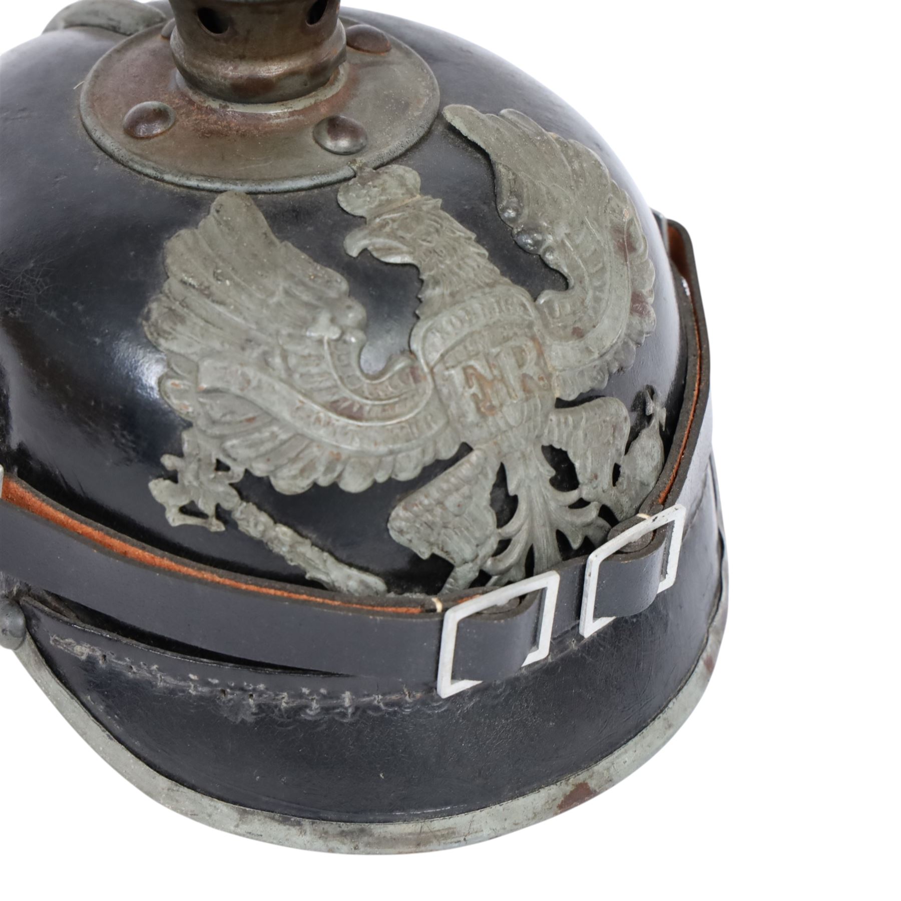 WWI Prussian M1915 Pickelhaube, the black leather skull with removable steel spike finial, steel eagle helmet plate and leather chin strap, one side with a black cockade, the other black and red