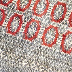 Jaldar Bokhara crimson and pale ground carpet, the field decorated with five rows of Gul motifs, within intricate multi-band border decorated with repeating geometric designs 