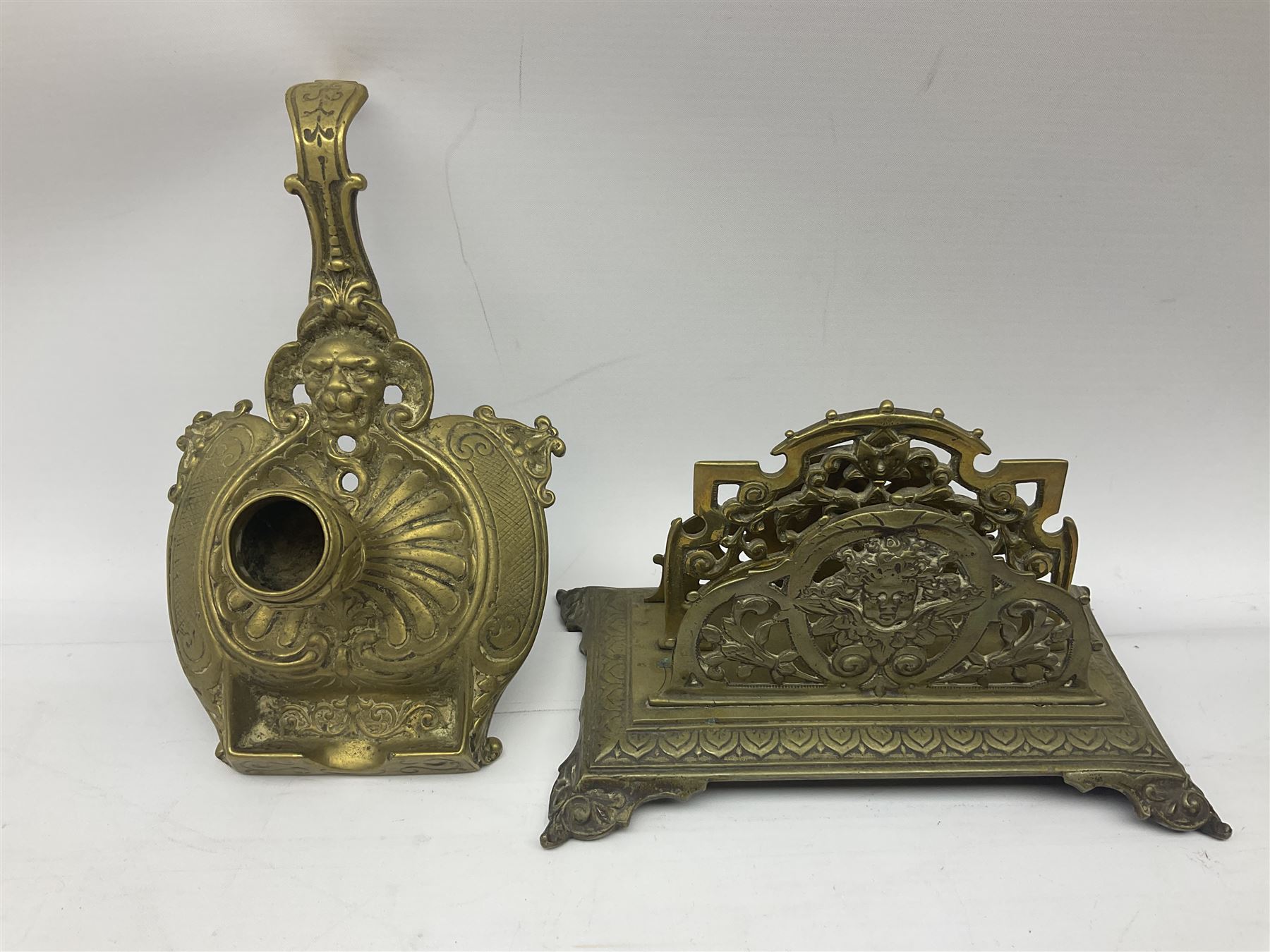 Collection of victorian and later brass desk accessories, to include a letter holder with cherub design, ink well of square form with hinged lid, brass table bell, brass casket with relief decoration, etc  