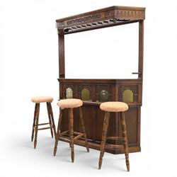 Old Charm - carved oak bar with three bar stools and associated Old Charm drinks cabinet, carved top with channels for glassware beneath, bar surface above glazed panels, shelves for glassware to the back, associated Old Charm drinks cabinet with fall front linenfold carving, above twin doors with shelved interior