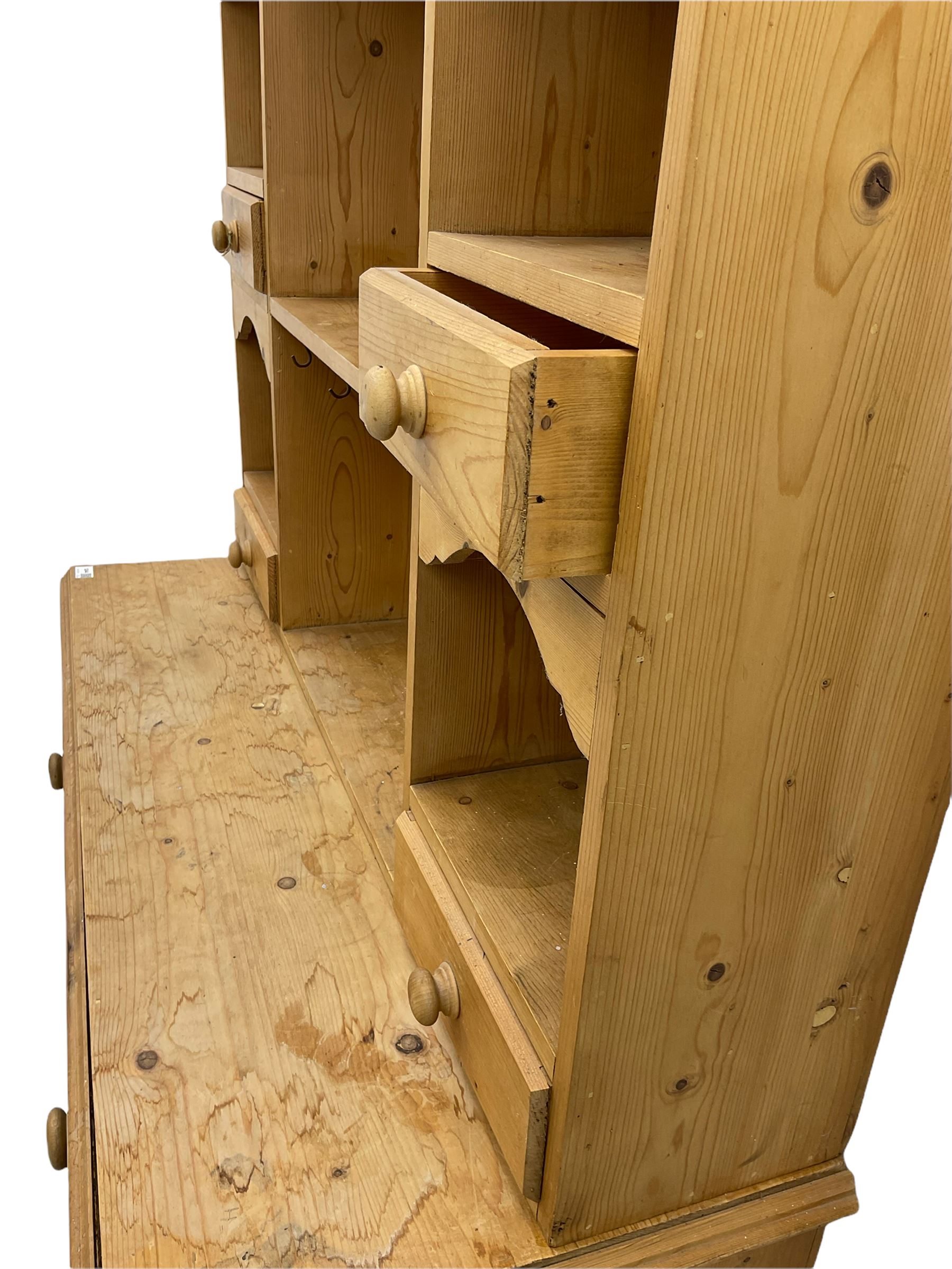Solid pine dresser, raised plate rack fitted with small drawers over two drawers and double cupboard, plinth base