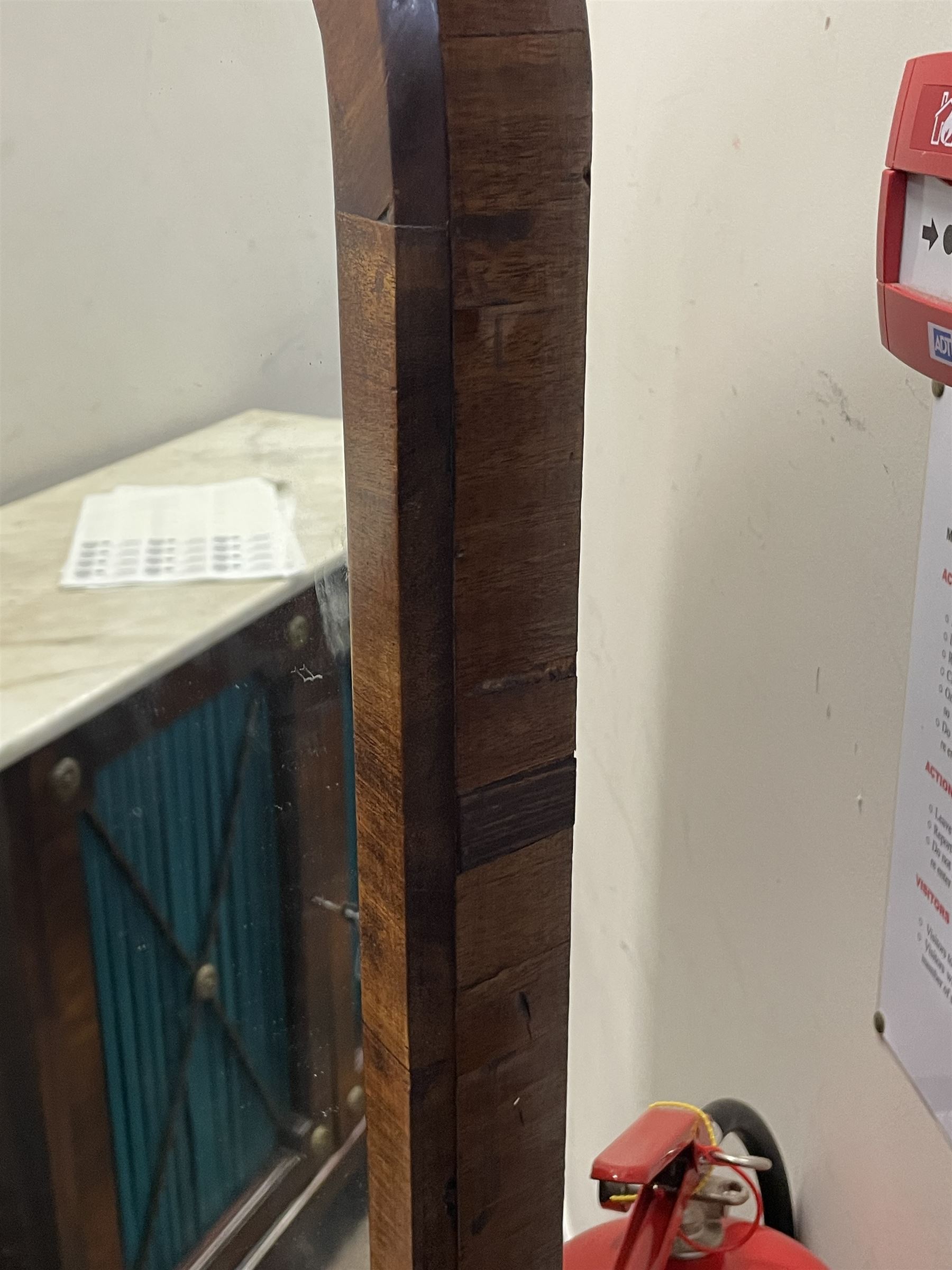 Early 19th century mahogany cheval dressing mirror, plain mirror plate within chamfered frame with arched top, on rolled horns and out-splayed rolled feet, united by turned stretcher 