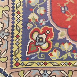Turkish Malatya type flatwoven rug, decorated with a red medallion field, stylised floral motifs and blue corner panels, enclosed by beige foliate border and outer floral guard band