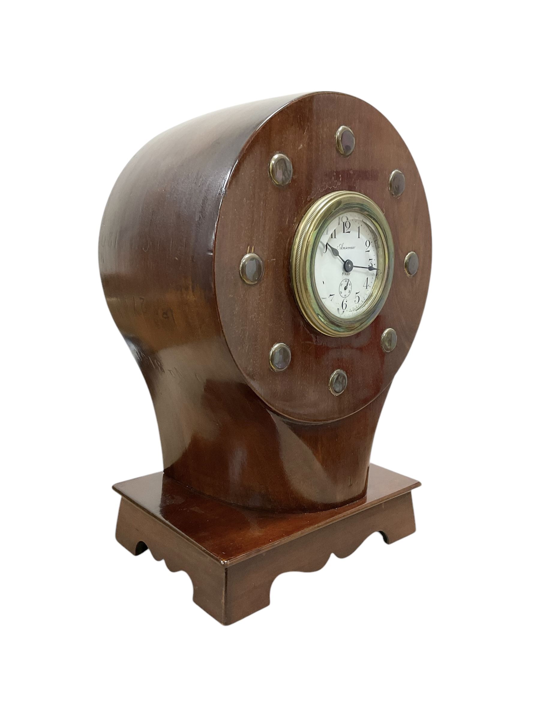 1920's-Aviation clock, mahogany case configured from part of an early 20th century aeroplane propellor, mounted on a conforming plinth with a shaped base, bolt holes filled with brass studs and fitted with an 8-day American spring driven Ansonia insertion movement with a porcelain dial, Arabic numerals, spade hands and seconds dial. Wound and set from the rear.