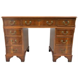 Georgian design yew wood twin pedestal desk, rectangular top with green leather inset writing surface, fitted with nine cock-beaded drawers, on bracket feet